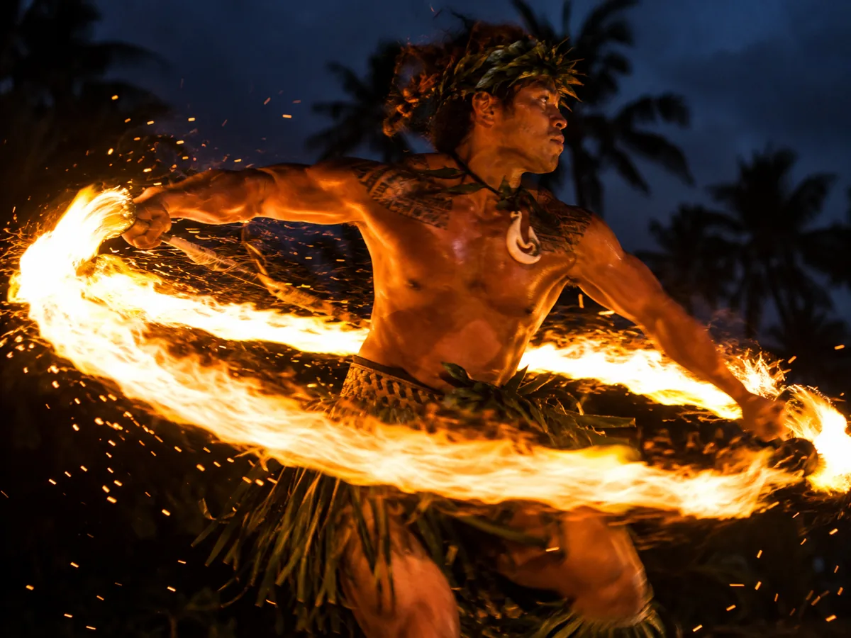 Polynesischer Feuermessertänzer, der nachts einen Feuerring dreht